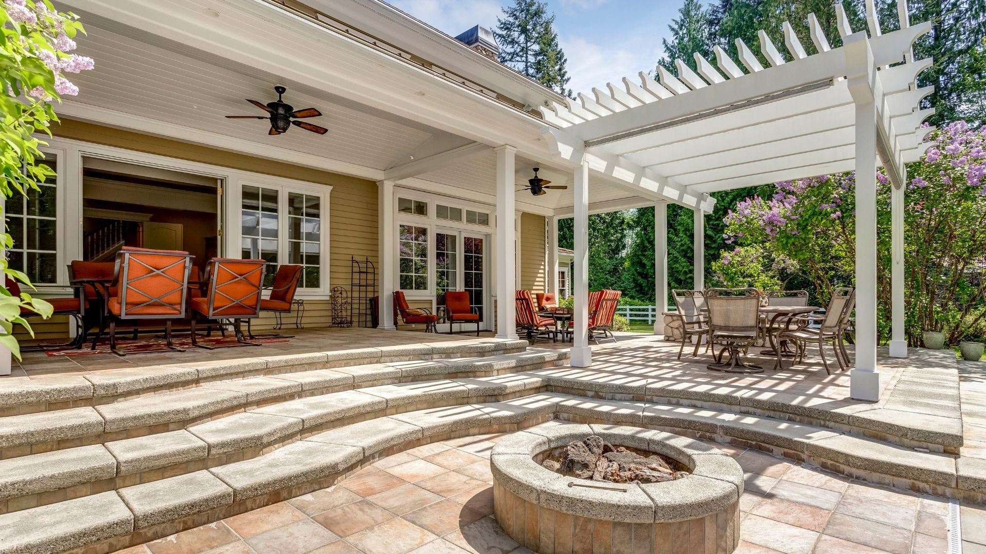 Luxurious outdoor patio with pergola, fire pit, and comfortable seating areas